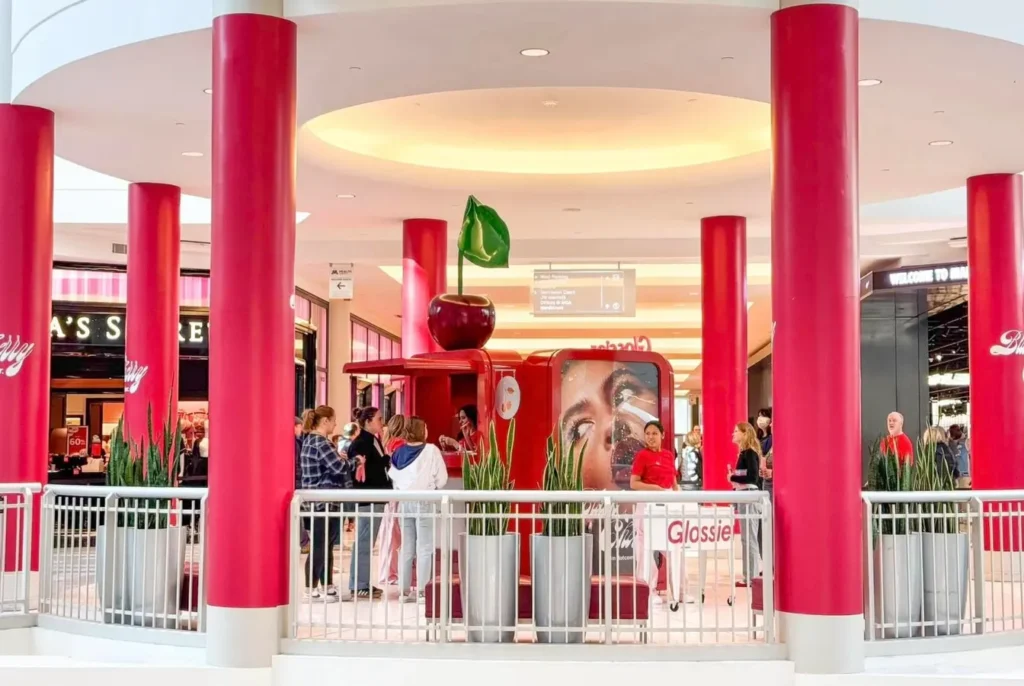 immersive branding in a mall, bright red pillars and white ceilings with huge marketing signs